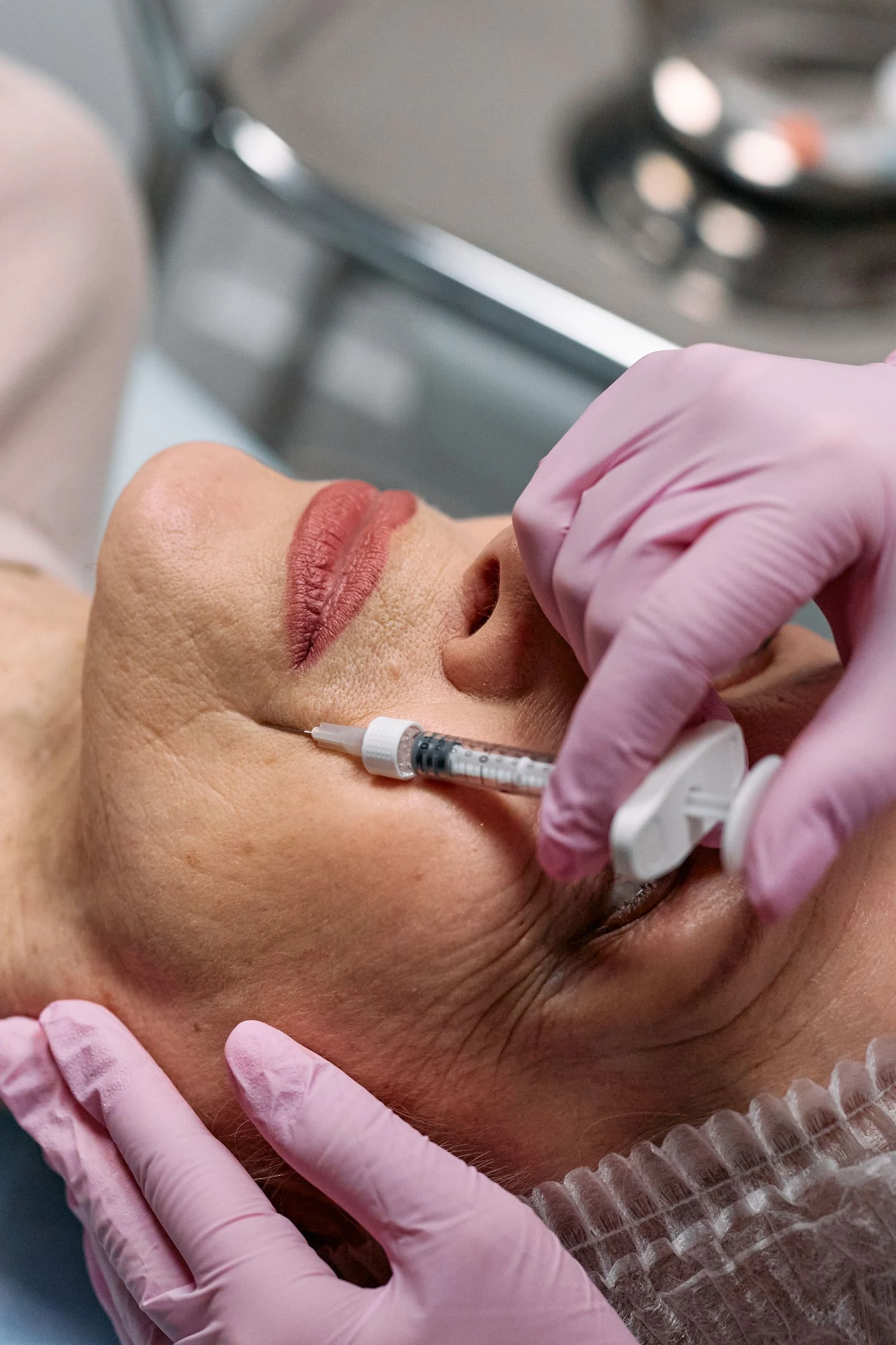 Stock photograph of a facial injectable treatment with gloved hands