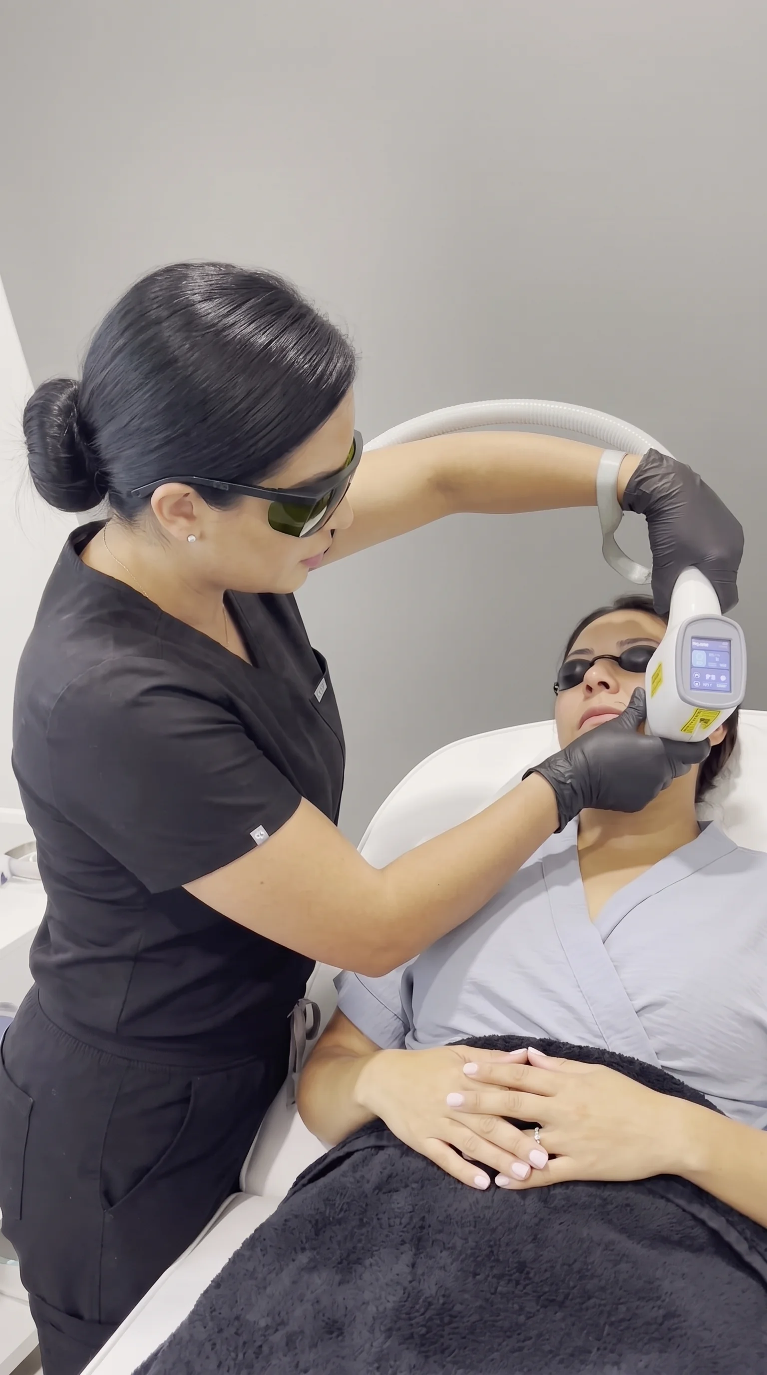 Esthetician wearing laser safety eyewear performing laser hair removal at THEIA Stone Oak